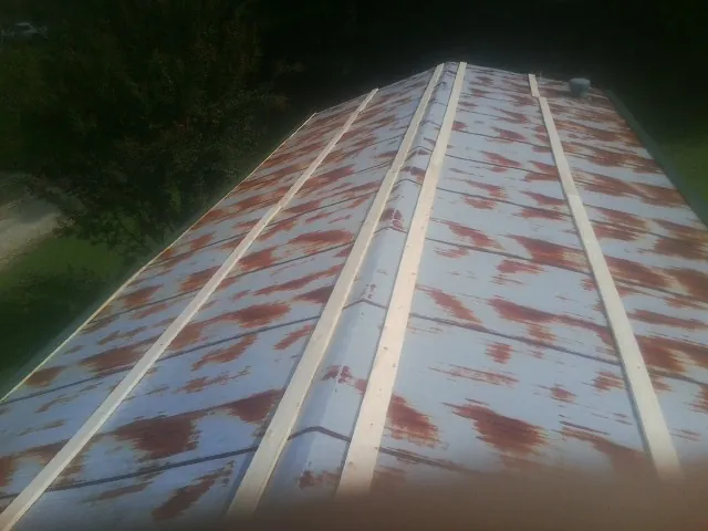 Rusted metal roof panels with new wood purlins before replacement — Storm Damage Roof Repair in Del Mar by Roofing Brothers
